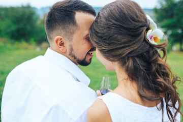 Fototapeta premium Beautiful caucasian couple kissing on a picnic by the lake. Honeymoon concept. Rear view.