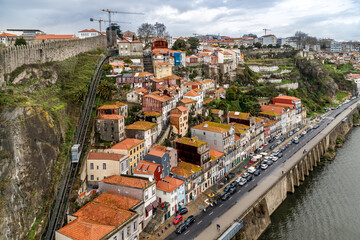Fototapeta na wymiar Porto, Portugal. View of embankment of Douro river, the old houses and funicular (cable railway) on the hill.