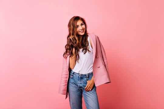 Laughing pretty girl in pink jacket expressing positive emotions. Studio portrait of appealing ginger woman isolated on light background. - Powered by Adobe
