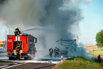 Naklejka premium firefighter extinguishes a burning car after an accident