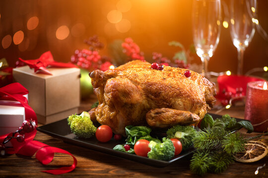 Christmas Dinner. Roasted Chicken. Winter Holiday Table Served, Decorated With Candles. Roast Turkey Over Blinking Background With Christmas Tree, Table Setting. Xmas