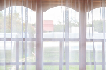 White curtain on the window. View from the room throw the window into the courtyard
