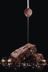 Brownie pieces on black background. Delicious chocolate pie.
