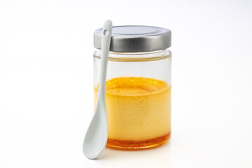 Cream caramel in a jar isolated on white background