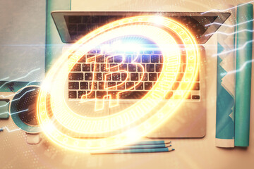 Blockchain theme hologram drawings over computer on the desktop background. Top view. Multi...