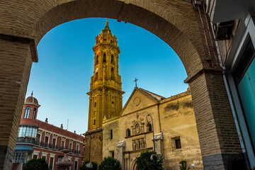 A view of the church of Saint Sebastion in Antequera, Spain framed by an archway on a summers...