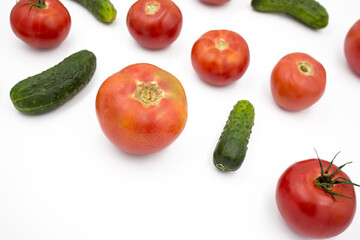 Fresh tomatoes and cucumrers on a white background, flat lay. Healthy food, vegan food.