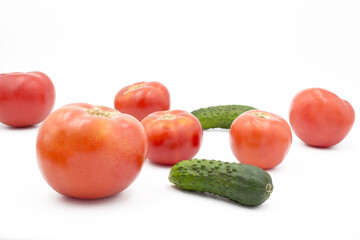 Fresh tomatoes and cucumrers on a white background, flat lay. Healthy food, vegan food.