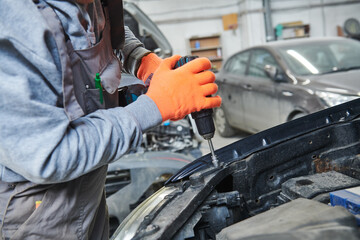 automobile repair shop. Worker assembling car body
