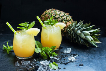 Pineapple fresh juice drink in glasses and ripe pineapple fruit
