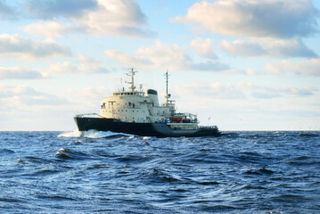 Soviet icebreaker in an open sea under dramatic sunset clouds. Freight transportation, global...