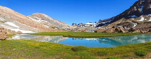 Fototapeta premium Wide Panoramic Landscape of Brazeau River Calm Blue Water with Scoured Rock Canyon and Distant Rocky Mountain Peaks of White Goat Wildernes, Alberta Canada