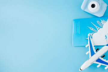 Camera, passport and airplane on light blue background.Summer or vacation concept. Copy space.