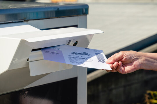 Everett, WA - USA / 07/30/2020:  Dropping Mail in Ballot into mail box
