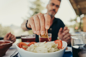 Man seasoning a salad.