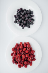 Black and red raspberry close-up on a white background. Healthy food, natural vitamins. Fresh berries