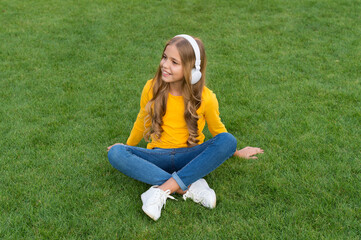 Cute smiling girl modern headphones enjoy music relaxing outdoors, audio library concept