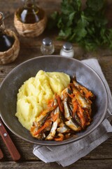 Braised anchovy in tomato sauce with onions and carrots and mashed potatoes.