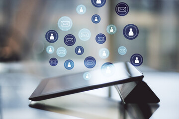 Digital tablet on desktop with glowing social media symbol.