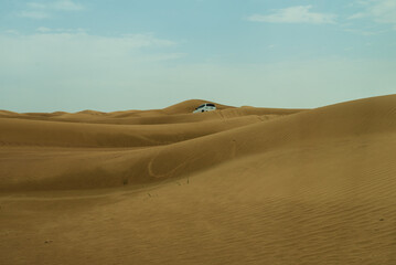 Lanscape of the red desert in Dubai, with yellow dune and blue sky, totally empty and quite.