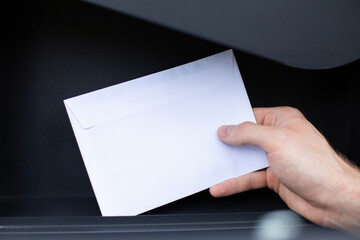 Sending, receiving mail. Letter in a white envelope in a mailbox.