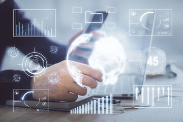 Double exposure of man's hands holding and using a phone and financial graph drawing. Analysis concept.