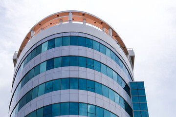 Obraz premium Circular building with lots of blue glass.