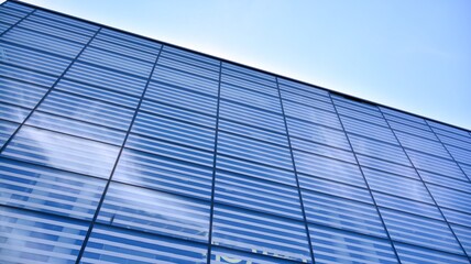 Commercial building close up. Abstract texture of blue glass modern building. Business background.
