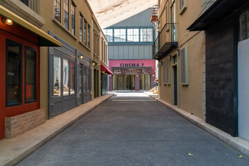 Fototapeta na wymiar Deserted street with commercial establishments. coffee shop, cinema, convenience store. TV set. Covid 19
