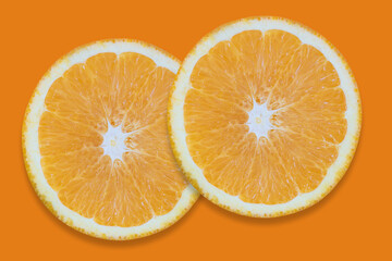 Oranges cut into pieces. Close-up texture. Copy space. Orange background.