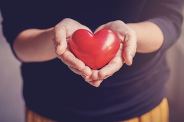 Woman holding red heart, health insurance, donation, happy charity volunteer concept, world mental health day, world heart day