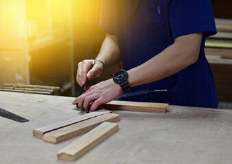 Close up thai engineer student measure wood, young male making measurement on the wooden