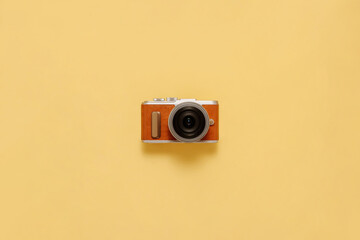 Fototapeta premium Photo camera on yellow background with drop shadow flat lay. Travel or vacation concept top view composition.