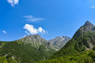 View of the beautiful countryside of North Ossetia. Sunny day. Beautiful summer landscape in the mountains. Grassy fields and hills. Rural landscapes