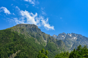Obraz premium View of the beautiful countryside of North Ossetia. Sunny day. Beautiful summer landscape in the mountains. Grassy fields and hills. Rural landscapes