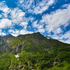 View of the beautiful countryside of North Ossetia. Sunny day. Beautiful summer landscape in the mountains. Grassy fields and hills. Rural landscapes