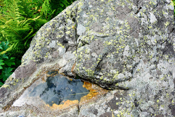 Small puddle in stones with sky reflection. Mountains of North Ossetia