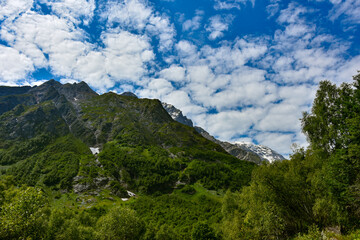 Obraz premium View of the beautiful countryside of North Ossetia. Sunny day. Beautiful summer landscape in the mountains. Grassy fields and hills. Rural landscapes
