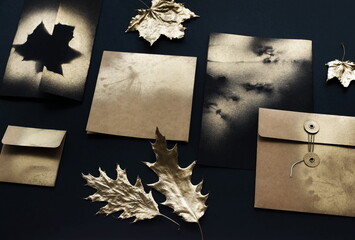 Autumn background. greeting craft cards mockup template, invitations blank in black, gold colors and fall gold leaves on black textured background. Flat lay, top view, copy space