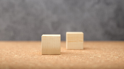 empty wooden cubes for own messages and icons on cork floor in front of a concrete wall