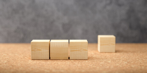 empty wooden cubes for own messages and icons on cork floor in front of a concrete wall