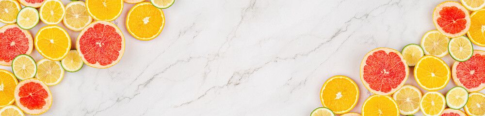 Creative background made of summer tropical fruits with grapefruit, orange, tangerine, lemon, lime on white marble background. Food concept. Flat lay, top view, copy space, mockup