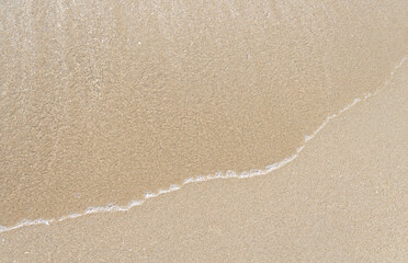 Close up ocean wave bubble on sandy beach. Background for vacation holiday and natural feeling.