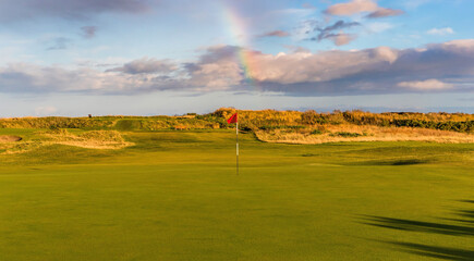 Links golf course with clouds and a rainbow