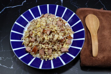 Traditional fried rice with cutting pork sausage and chicken egg on the plate. Famous stirred cooked rice in Japanese style. 