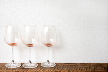 Empty wine glass on white wall