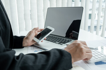 The hands of a male businesswoman use the calculator are analyzing and calculating the annual income and expenses in a financial graph that shows results To summarize balances overall in office