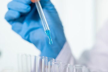 Medical scientists released a sample pipette into a test tube to analyze the virus in a chemical...