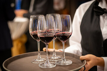 Obraz premium waiter serving glass of red wine