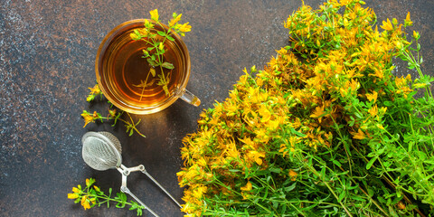 Hypericum.Glass cup with herbal tea . Hypericum on a dark background. Top view